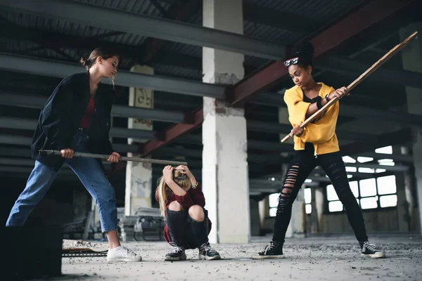 Teenage girl attaccata da teppisti in edifici abbandonati, violenza tra gang e bullismo concetto. — Foto Stock