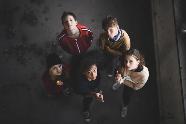 Вид группы подростков, стоящих в закрытом помещении в заброшенном здании, смотрящих в камеру. — стоковое фото