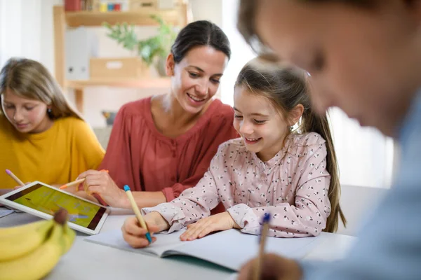 Grupp av hemskolebarn med lärare som studerar inomhus, coronavirus koncept. — Stockfoto