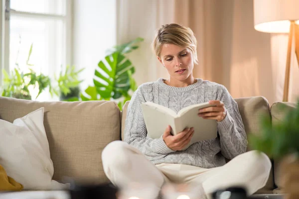 Porträtt av kvinna avkopplande med bok inomhus, mental hälsovård koncept. — Stockfoto