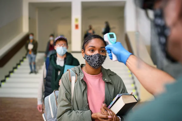 Young students back at college or university, coronavirus and measuring temperature concept. — Stock Photo, Image