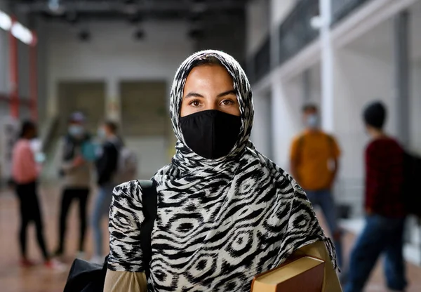 Исламский студент в маске в колледже или университете, коронавирусная концепция. — стоковое фото
