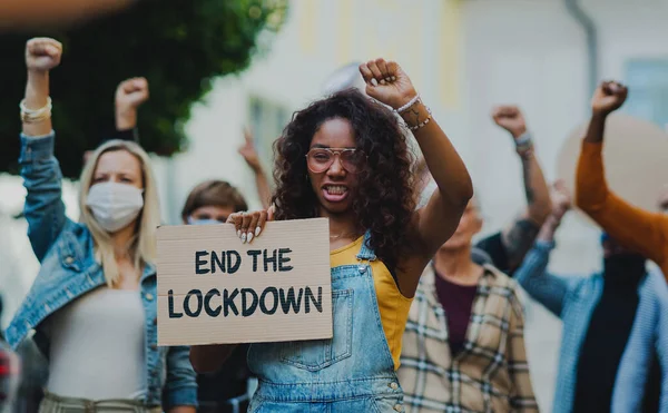 Mensen met borden en affiches op openbare demonstratie, einde van lockdown en coronavirus concept. — Stockfoto