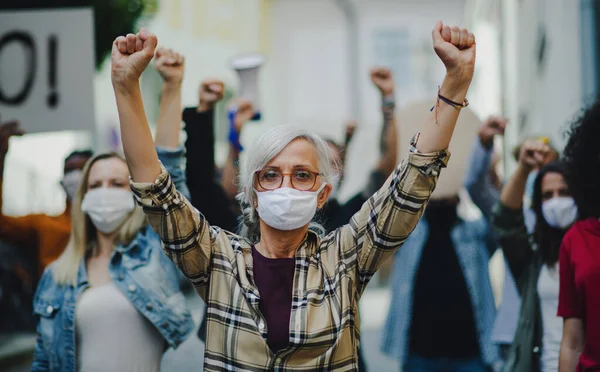 Emberek csoportja az utcán tüntető aktivisták, nők felvonulása, demonstrációja és a koronavírus koncepciója. — Stock Fotó