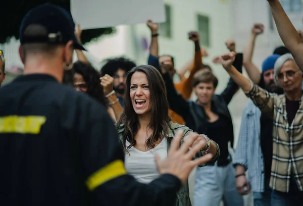 Policie zastavuje skupinu aktivistů se zvednutými pěstmi protestujících na ulicích, koncept demonstrace BLM. — Stock fotografie