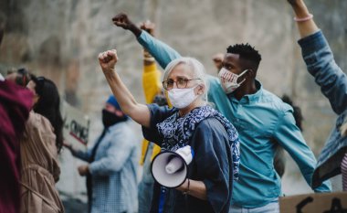 Sokaklarda gösteri, BLM gösterisi ve koronavirüs konseptini protesto eden yumruklarını kaldırmış bir grup aktivist.