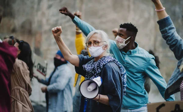 Groep mensen activisten met opgeheven vuisten protesteren op straat, BLM demonstratie en coronavirus concept. — Stockfoto