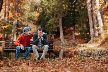 Yaşlı baba oğlunu teselli ediyor. Sonbahar mevsimi.