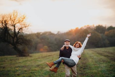 Son sınıf çifti için romantik bir an. Karısını kucağında taşıyan koca..