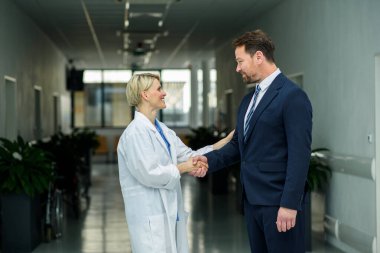 İlaç satış temsilcisi kadın doktora yeni ilaçlar veriyor, tablette sunumunu gösteriyor..