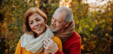 Son sınıf çifti arasındaki romantik an, sonbahar doğasının ortasında duruyor..
