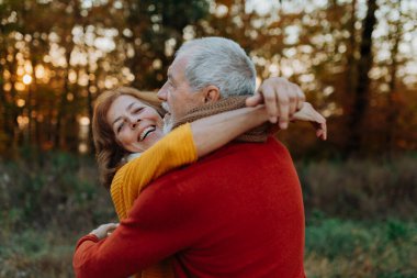 Son sınıf çifti arasındaki romantik an, sonbahar doğasının ortasında duruyor..