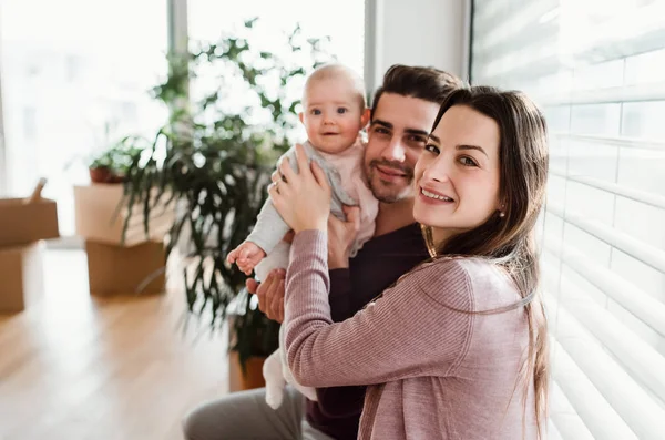 Portrait D Un Jeune Couple Avec Un Bebe Et Des Boites En Carton Emmenageant Dans Une Nouvelle Maison Fenetre Heureux Stock Photo Portrait D Un Jeune Couple Avec Un Bebe Et Des Boites En Carton Emmenageant Dans Une Nouvelle Maison Fenetre Heureux Stock Photo