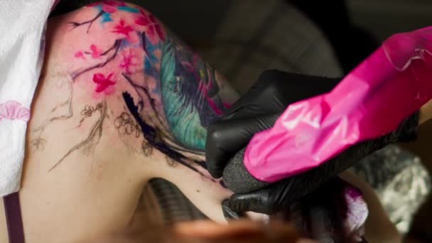 Lány tetoválás mester teszi a tetoválás, hogy az ügyfél.
