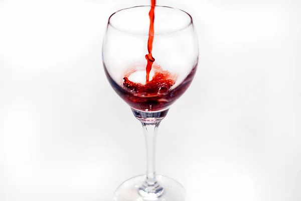 The pouring of a red wine into a wineglass