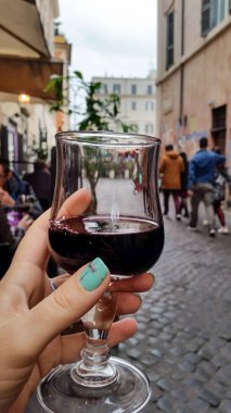 Bir bardak kırmızı şarap Roma sokak bir kafede bir kadının elinde