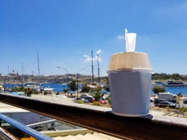 Güneşli bir günde bir veranda zemin bir bağlantı noktasının karşı boş alanı ile dondurma fincan duruyor