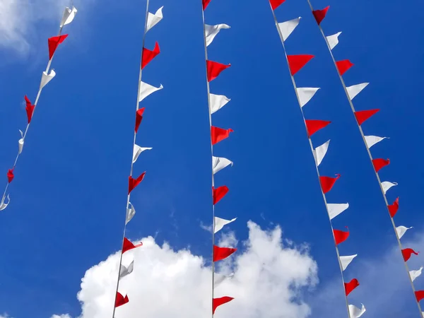 Garland mavi gökyüzü arka plan üzerinde kırmızı ve beyaz üçgen bayrakları