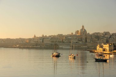 Erken sabah su Valletta Grand Harbour gemilerin yansımalar