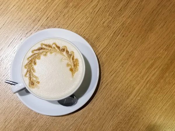 Filiżanka kawy latte art na drewnianym stole z bliska — Zdjęcie stockowe