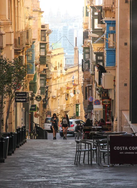 Valletta, Malta - 2018 olabilir: İki kız arasında kafe sandalye Valletta düz sokakta yürümek