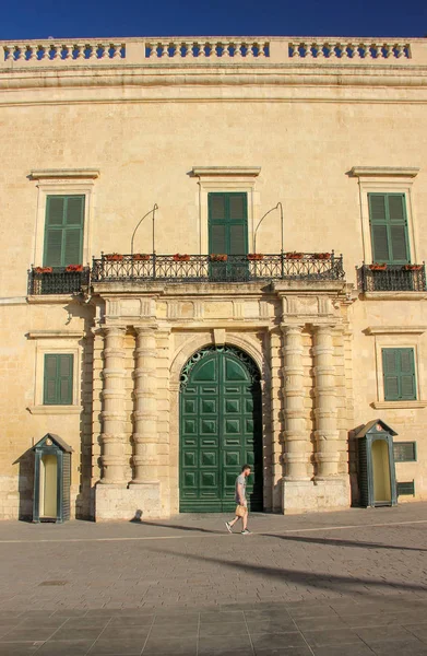 Mannen promenad i Valletta längs nära stora gröna porten av Grandmaster Palace — Stockfoto