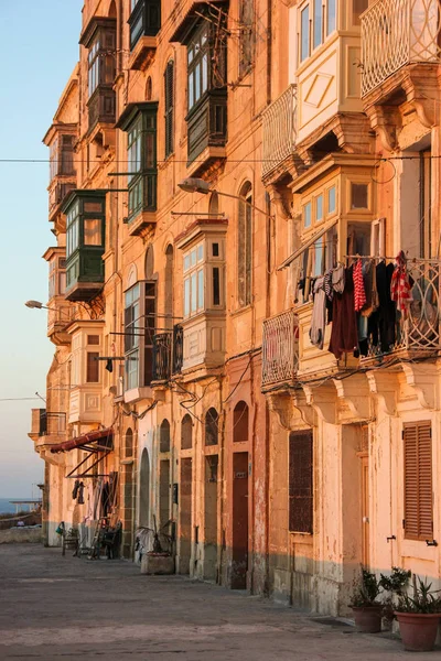 Verkliga livet på Valletta street under orange solnedgång - ingen på trottoaren — Stockfoto