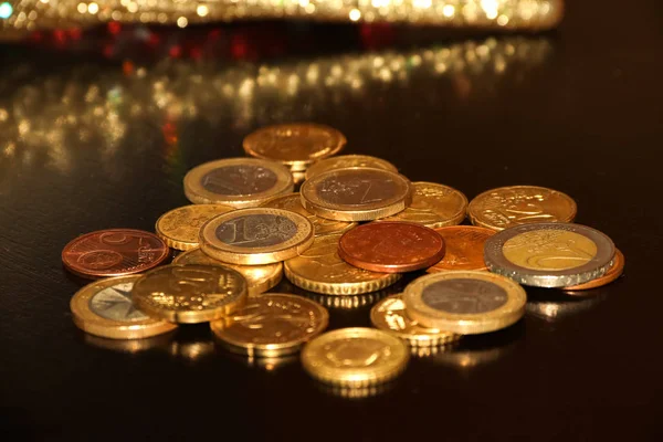 Bando de moedas de euro em fundo preto com reflexo borrado de brilho brinquedo do ano novo — Fotografia de Stock