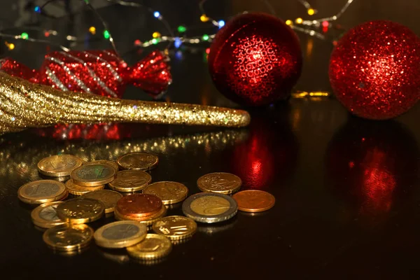 Bando de moedas de euro em fundo preto com reflexos desfocados de brinquedos de Ano Novo — Fotografia de Stock