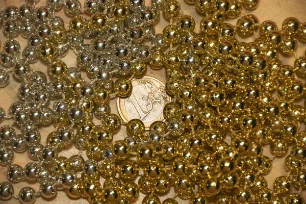 Uma moeda de euro em contas de brilho de metal dourado e prata claras — Fotografia de Stock