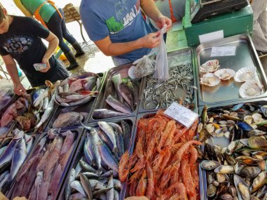 Marsaxlokk, Malta - Mayıs 2018: Satıcı prepearing birçok tür balık, deniz tarağı ve üzerinde karidesleri sayaç Satılık