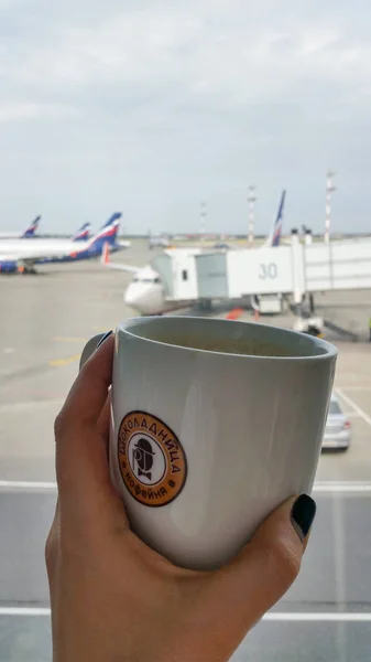 Moskova, Rusya - Nisan 2016: kahve Shokoladnitsa kahve evi etikel kız el ile. Aeroflot uçak üniforma ve jet uçakları arka plan bulanık üzerinde köprü. Sheremetyevo Havaalanı - Svo