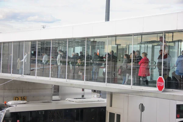 Parigi, Francia - aprile 2016: persone che si imbarcano su una pista d'atterraggio utilizzando un ponte a getto trasparente. Vista laterale dal terminale — Foto Stock
