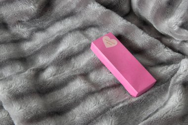 Aşk gümüş gri tüylü faux kürk battaniye arka plan üzerinde bir kalp ile büyük pembe hediye kutusu