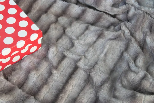 Büyük kırmızı beyaz köşesinde aşk el yapımı hediye kutusu gümüş gri tüylü faux kürk battaniye arka plan üzerinde noktalı. Boş alan