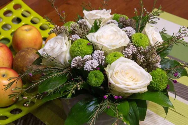 Çiçekler beyaz Düğünçiçeği düğün çiçeği ile ahşap masa üzerinde yeşil karanfil ve küçük mor ve beyaz çiçekler güzel buket. Tabak meyve elma ve armut ile noktalı ışık yeşil delik