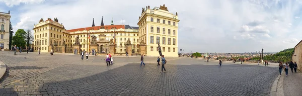 Vue panoramique sur le magnifique bâtiment de la résidence du Président de la République tchèque au Château de Prague. Les touristes marchent le long de la place pavée surplombant la ville . — Photo