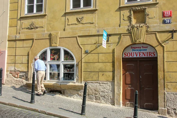 Прага, Чешская Республика - май 2016 года: Старик идет по сладкой старой улице возле красивого фасада традиционного здания в квартале Мала Страна — стоковое фото