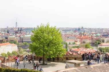 Prag kalesinden Prag'ın tarihi merkezine, binalara ve eski kentin simge yapılarına kadar muhteşem manzara. Güzel veiw noktasında yürüyen turistler