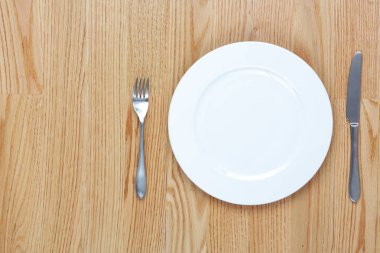 Yemek çatal ve bıçak yanında bir plaka üzerinde bir tahta masa ile kopya s