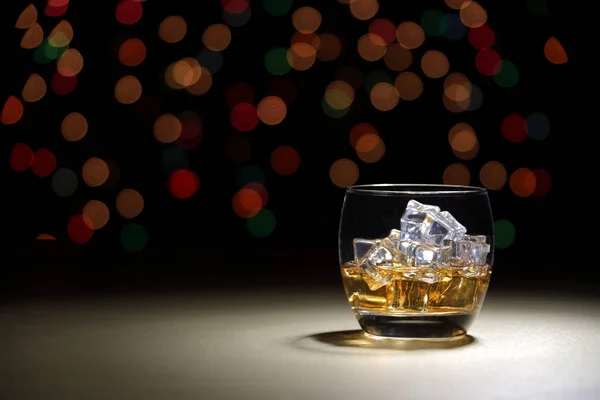 Scotch in tumbler on gold surface with bokeh background — Stock Photo, Image