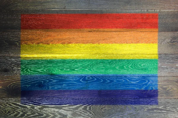 Gay orgullo arco iris bandera en rústico viejo madera superficie fondo —  Fotos de Stock