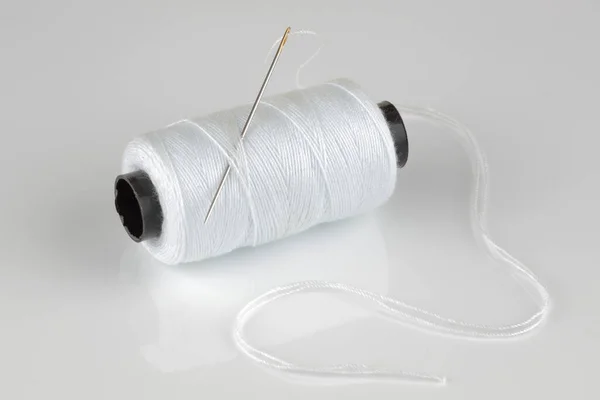 Carrete de algodón blanco y aguja con reflexión — Foto de Stock