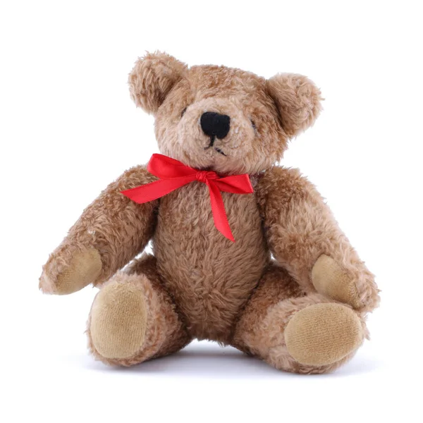 Teddy beer met rood lint zittend op wit Stockafbeelding