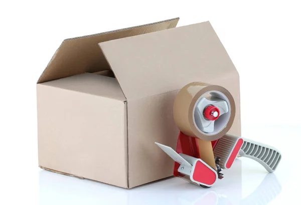 Cardboard box and packing tape gun on white — Stock Photo, Image