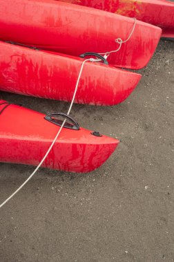 Boş kırmızı plastik eğlence kayaks Kiralık veya Kiralık, yağmurlu bir günde tarihinde saat sonra kumsalda depolanan. Hilal Beach, Surrey, British Columbia, Kanada.