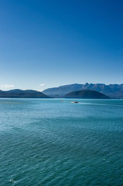 Mavna güneşli bir günde çekerek römorkör. Gastineau kanal, Juneau, Alaska, ABD.