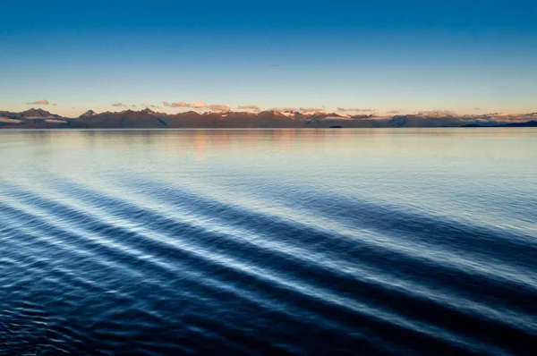 Πλοίο τόξο κύματος κυματισμός λιμάνι πλευρά και αυγή αναμμένο βουνά στο φόντο. Αλάσκα, Ηνωμένες Πολιτείες — Φωτογραφία Αρχείου