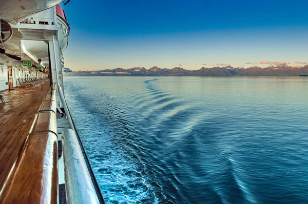 Hajnalban a fény, a hegyek és a tengerjáró hajó kikötő oldalán óceán hullámai, Alaska, Amerikai Egyesült Államok. — Stock Fotó