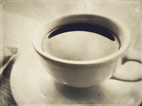 Schwarzer Kaffee in weißer Keramiktasse und Untertasse in einem Café unter Fensterlicht. — Stockfoto